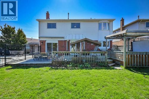 Expansive backyard featuring a multi-level wooden deck, a pergola, and a private pool area with black metal fencing - 44 Lorilee Crescent, Kitchener, ON - Outdoor