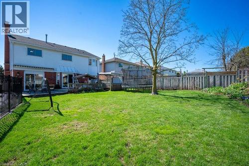Spacious backyard featuring a manicured lawn, a mature tree, and a wooden privacy fence - 44 Lorilee Crescent, Kitchener, ON - Outdoor