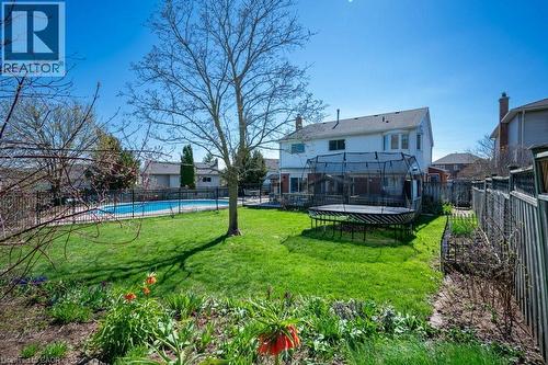 Expansive backyard featuring a manicured lawn, a fenced in-ground swimming pool, and mature trees - 44 Lorilee Crescent, Kitchener, ON - Outdoor With In Ground Pool With Backyard