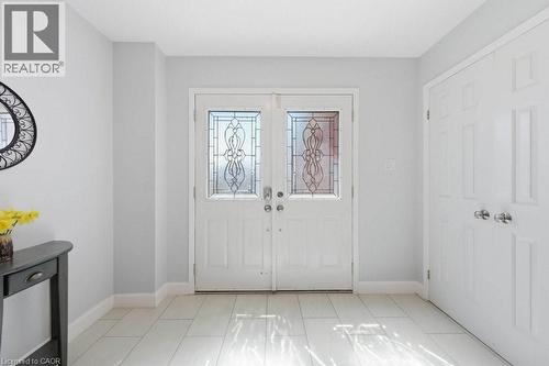 Entryway featuring double doors with decorative glass panels, light-toned tile flooring, and white baseboards - 44 Lorilee Crescent, Kitchener, ON - Indoor Photo Showing Other Room
