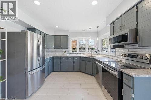 Kitchen featuring recessed lighting, light-toned tile flooring, gray cabinetry, light countertops, and stainless steel appliances - 44 Lorilee Crescent, Kitchener, ON - Indoor Photo Showing Kitchen With Double Sink With Upgraded Kitchen