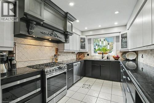 Kitchen featuring light and dark cabinetry, dark countertops, and a tiled backsplash - 2324 Homer Drive, Burlington, ON - Indoor Photo Showing Kitchen With Upgraded Kitchen