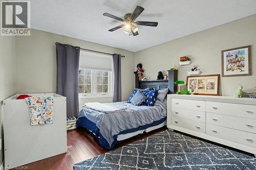 Hardwood-finish flooring, a multi-pane window with blinds, and a ceiling fan with integrated lighting - 2324 Homer Drive, Burlington, ON - Indoor Photo Showing Bedroom
