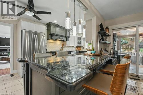 Kitchen island with a dark granite countertop and integrated seating - 2324 Homer Drive, Burlington, ON - Indoor Photo Showing Kitchen