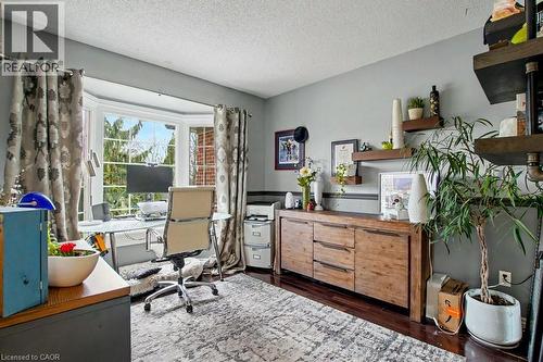 Bay window with exterior tree line, rich wood-finish flooring, and a built-in wooden sideboard with shelving - 2324 Homer Drive, Burlington, ON - Indoor Photo Showing Office