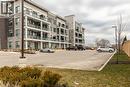 Multi-story building featuring brick and stone cladding, multiple balconies with glass railings, and expansive windows - 120 Springvalley Crescent Unit# 208, Hamilton, ON  - Outdoor With Balcony With Facade 