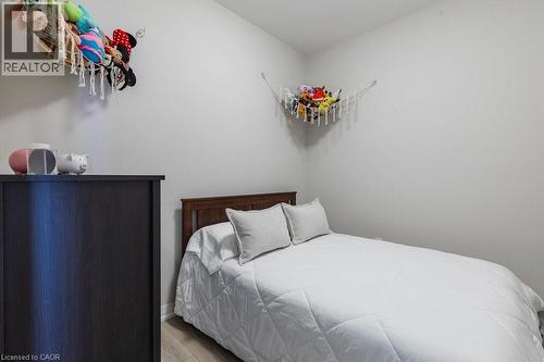 Bright room with light gray walls and wood-finish flooring - 120 Springvalley Crescent Unit# 208, Hamilton, ON - Indoor Photo Showing Bedroom