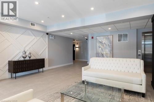 Lobby featuring decorative wall paneling, recessed lighting, tile flooring, and a stainless steel elevator - 120 Springvalley Crescent Unit# 208, Hamilton, ON - Indoor