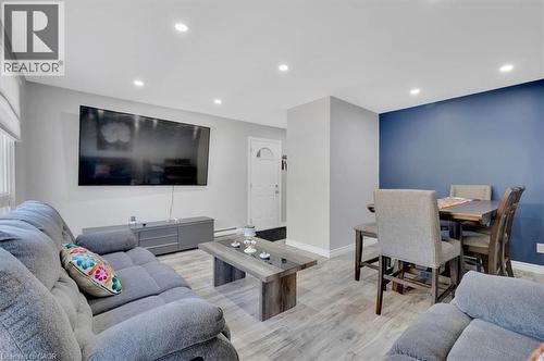 Open concept living space featuring light wood-finish flooring, recessed lighting, and a prominent accent wall - 168 Silver Aspen Crescent, Kitchener, ON - Indoor Photo Showing Living Room
