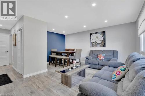 Spacious living area featuring wood-finish flooring, recessed lighting, and a window with roller shades - 168 Silver Aspen Crescent, Kitchener, ON - Indoor