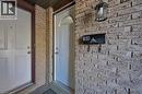 Brick facade featuring an exterior light fixture, a mailbox with house numbers, and a paneled entry door with an arched transom - 168 Silver Aspen Crescent, Kitchener, ON  -  With Fireplace 