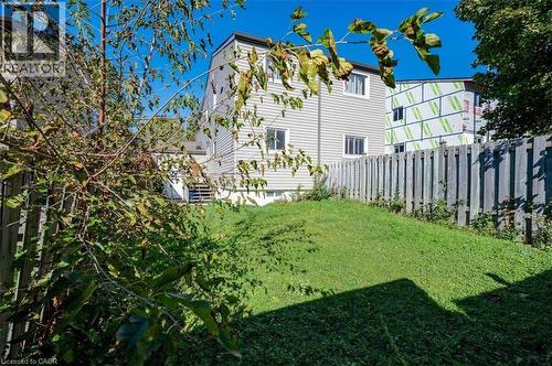 Expansive grassy yard area with a wooden privacy fence and established trees - 168 Silver Aspen Crescent, Kitchener, ON - Outdoor