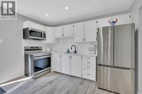 Kitchen featuring white cabinetry, subway tile backsplash, stainless steel appliances, wood-finish flooring, and recessed lighting - 168 Silver Aspen Crescent, Kitchener, ON - Indoor Photo Showing Kitchen