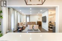 Family area with dark wood-style floors, recessed lighting - 