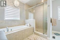 Bathroom featuring a bath, a shower stall, healthy amount of natural light, and tile patterned floors - 