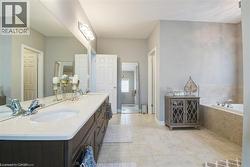 Full bathroom with double vanity, a bath, and light tile patterned floors - 