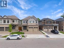 View of front of house featuring a residential view, exposed concrete driveway, an attached garage, and brick siding - 