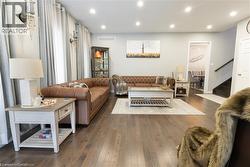Living area featuring recessed lighting, dark wood-style flooring, and stairway - 