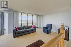 Living area featuring a textured ceiling, light wood-style floors, and floor to ceiling windows - 