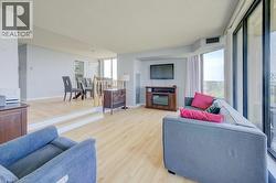 Living area with wood finished floors, a glass covered fireplace, and a textured ceiling - 