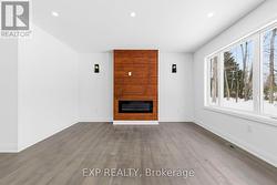 Living room view w/ pine feature wall & fireplace - 