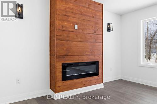 Pine feature wall & fireplace - 49 Beaufort Crescent, Tiny, ON - Indoor Photo Showing Living Room With Fireplace