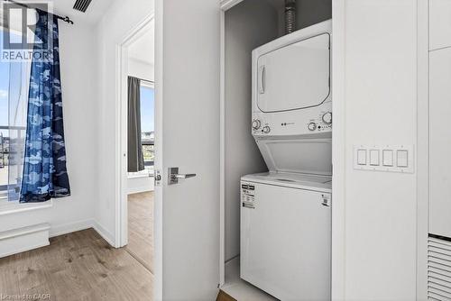 Built-in stacked laundry appliances within a dedicated closet - 500 Plains Road E Unit# 207, Burlington, ON - Indoor Photo Showing Laundry Room