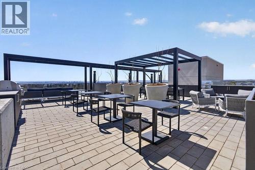 Expansive rooftop patio featuring paver flooring, multiple pergolas, and built-in outdoor kitchen elements - 500 Plains Road E Unit# 207, Burlington, ON - Outdoor