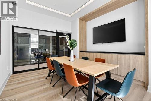 Conference room featuring wood-finish flooring, a contemporary meeting table, and integrated wall cabinetry - 500 Plains Road E Unit# 207, Burlington, ON - Indoor