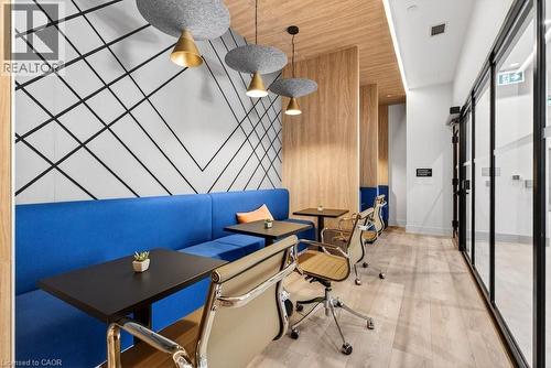 Modern interior featuring a geometric accent wall and a built-in blue banquette - 500 Plains Road E Unit# 207, Burlington, ON - Indoor Photo Showing Office