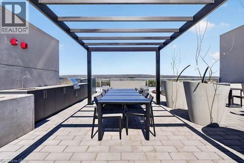 Rooftop patio featuring a dark metal pergola, paver flooring, and an outdoor kitchen with an integrated grill and sink - 500 Plains Road E Unit# 207, Burlington, ON - Outdoor