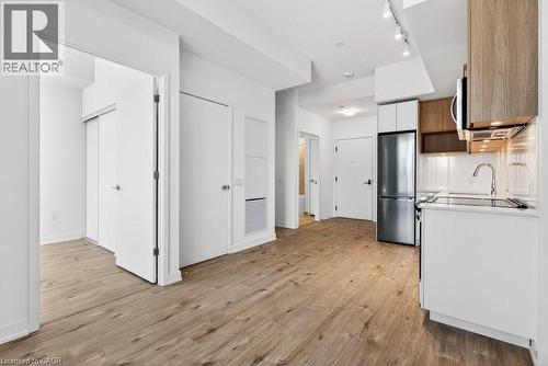 Contemporary kitchen featuring light wood-finish cabinetry, stainless steel appliances, white subway tile backsplash, and track lighting - 500 Plains Road E Unit# 207, Burlington, ON - Indoor Photo Showing Kitchen With Stainless Steel Kitchen