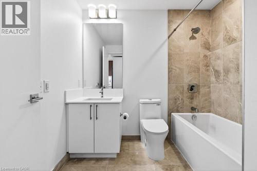 Contemporary bathroom featuring a white vanity with integrated sink, quartz countertop, and brushed nickel hardware - 500 Plains Road E Unit# 207, Burlington, ON - Indoor Photo Showing Bathroom