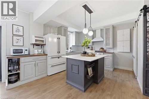 Kitchen featuring wood-finish flooring and a central island with a light-toned countertop - 361 Cumberland Avenue, Hamilton, ON - Indoor Photo Showing Kitchen