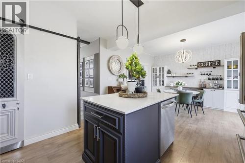 Central kitchen island with a light-toned countertop and built-in dishwasher - 361 Cumberland Avenue, Hamilton, ON - Indoor