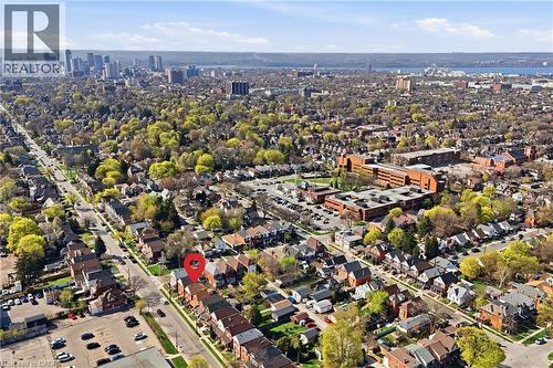 Aerial perspective of a tree-lined residential area with urban architecture, a distant cityscape, a substantial body of water, and surrounding green spaces under a clear sky - 361 Cumberland Avenue, Hamilton, ON - Outdoor With View