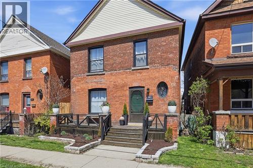 Brick exterior featuring a dark green front door and an oval window - 361 Cumberland Avenue, Hamilton, ON - Outdoor With Deck Patio Veranda With Exterior