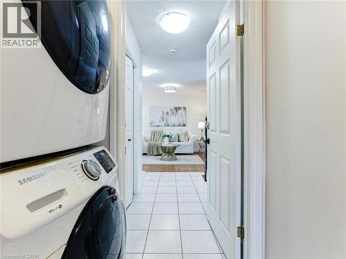 Dedicated laundry area featuring a stacked washer and dryer unit - 154 Deerpath Drive, Guelph, ON - Indoor Photo Showing Laundry Room