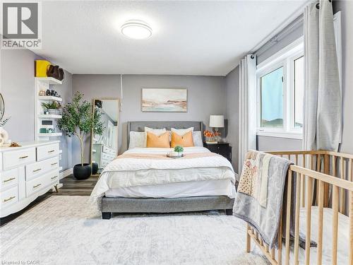 Spacious bedroom featuring light gray walls, a large window with drapes, wood-finish flooring, and a decorative area rug - 154 Deerpath Drive, Guelph, ON - Indoor Photo Showing Bedroom