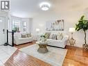 Bright living area featuring wood-finish flooring, white walls, a bay window with multiple panes, a white ceiling, and a flush mount light fixture - 154 Deerpath Drive, Guelph, ON  - Indoor Photo Showing Living Room 