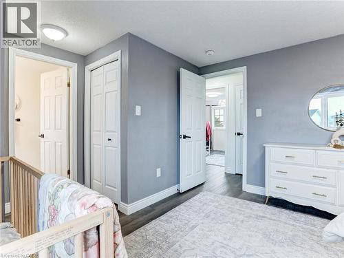 Interior space featuring grey walls, white trim, wood-finish flooring, and multiple white paneled doors with dark hardware - 154 Deerpath Drive, Guelph, ON - Indoor