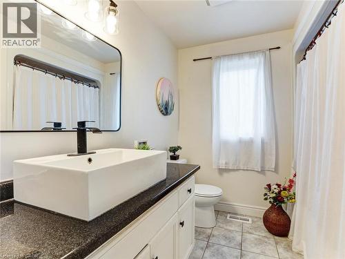 Bathroom featuring a rectangular vessel sink with a black faucet, set on a dark countertop - 154 Deerpath Drive, Guelph, ON - Indoor Photo Showing Bathroom