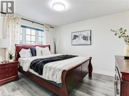Bright bedroom featuring a multi-pane window, flush-mount ceiling light, and light wood-finish flooring - 154 Deerpath Drive, Guelph, ON - Indoor Photo Showing Bedroom