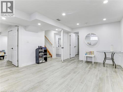 Finished lower level featuring light wood-finish flooring, recessed lighting, white trim, and multiple doorways - 154 Deerpath Drive, Guelph, ON - Indoor Photo Showing Other Room