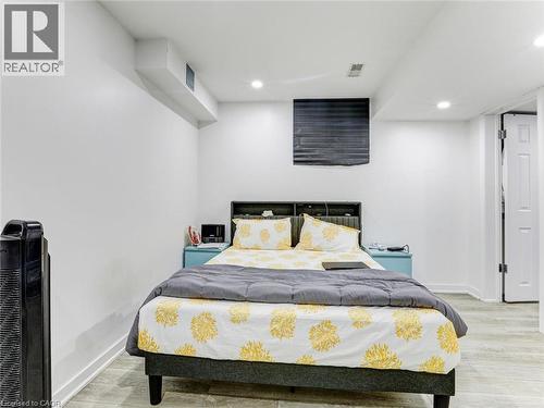 Recessed lighting illuminates this room, featuring light wood-finish flooring and white painted walls - 154 Deerpath Drive, Guelph, ON - Indoor Photo Showing Bedroom