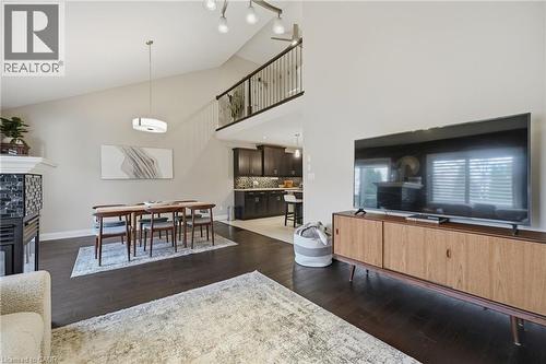 Open-concept living space featuring vaulted ceilings and dark wood-finish flooring - 7 Gibson Place Unit# 26, St. Catharines, ON - Indoor Photo Showing Living Room
