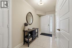 Entryway featuring a white paneled door with sidelight, overhead flush-mount lighting, and light-toned tile flooring - 