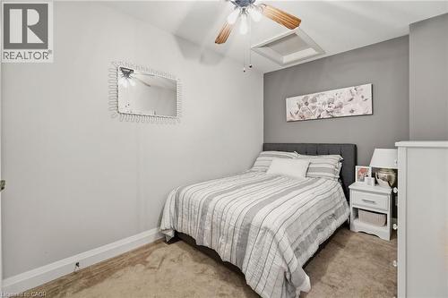 Bedroom featuring carpeted flooring, a ceiling fan with light fixture, and a built-in overhead light panel - 7 Gibson Place Unit# 26, St. Catharines, ON - Indoor Photo Showing Bedroom