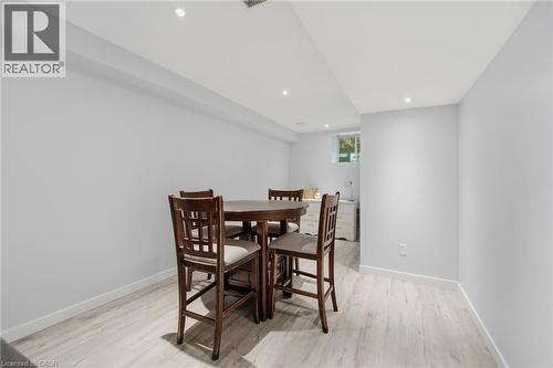 Lower-level living space featuring recessed lighting, light wood-finish flooring, white baseboards, and a window providing natural light - 7 Gibson Place Unit# 26, St. Catharines, ON - Indoor Photo Showing Dining Room