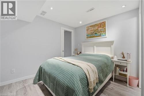 Bedroom featuring light gray walls, recessed lighting, white trim, and wood-finish flooring - 7 Gibson Place Unit# 26, St. Catharines, ON - Indoor Photo Showing Bedroom